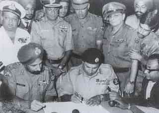 Lt Gen Niazi signing the Instrument of Surrender under the gaze of Lt Gen Aurora. (Indian Navy)
