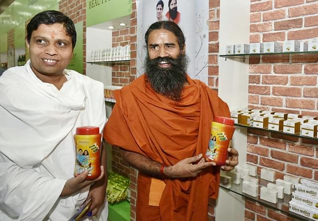 Yoga Guru Baba Ramdev with Acharya Balkrishna shows Patanjali’s products. (Arvind Yadav/Hindustan Times via Getty Images)