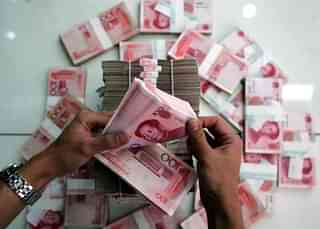 A clerk counts stacks of Chinese yuan at a bank in Beijing (China Photos/Getty Images)