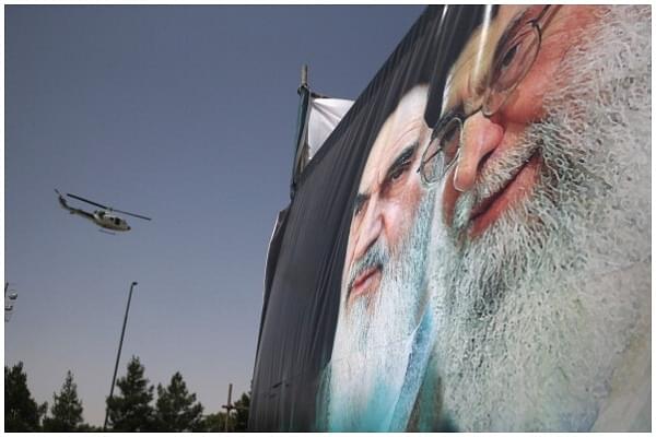  An Iranian police helicopter passes above portraits of Iran’s supreme leader Ayatollah Ali Khamenei (R) and the former Ayatollah Khomeini outside Khomeini’s shrine on the 25th anniversary of his death on June 4, 2014 (John Moore/Getty Images)
