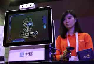 An Alibaba employee demonstrates ‘Smile to Pay’ that uses Facial Recognition to authorise payments (Alex Wong/Getty Images)