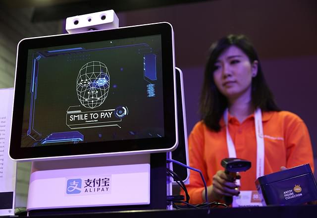 An Alibaba employee demonstrates ‘Smile to Pay’ that uses Facial Recognition to authorise payments (Alex Wong/Getty Images)