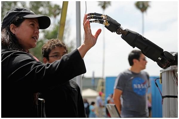 A woman reaches to touch a robotic arm developed by the Johns Hopkins University Applied Physics Laboratory is on display at the Defense Advanced Research Projects Agency (DARPA) Robotics Challenge Expo at the Fairplex June 6, 2015 in Pomona, California. (Chip Somodevilla/Getty Images)