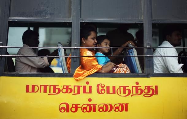A lady with a young boy on her lap look out the window as they ride the bus. The transport employees have been risking their lives to ensure the communters’ safety. (Mark Kolbe/Getty Images)
