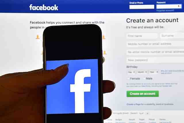 A person holds an iPhone displaying the Facebook app logo. (Photo by Carl Court/GettyImages)