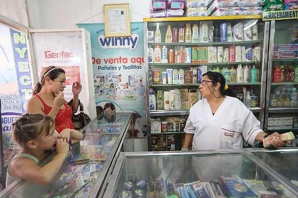 A Venezuelan woman (L) waits to purchase items from a pharmacy (Mario Tama/Getty Images)