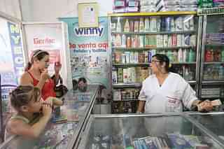 A Venezuelan woman (L) waits to purchase items from a pharmacy (Mario Tama/Getty Images)