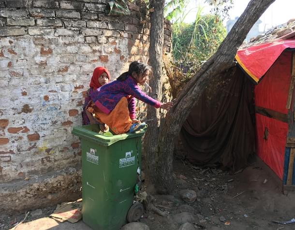 A girl plays with trash at a Rohingya camp in Bhatindi’s Kiryani Talab