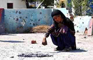  A lady inspects the rooftop of a house damaged by mortar shells fired from the Pakistan side of the border. (Nitin Kanotra/Hindustan Times via Getty Images)