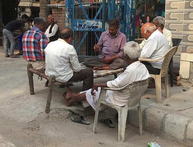 Men play cards on a lazy Wednesday noon. The mood before Holi is downbeat
