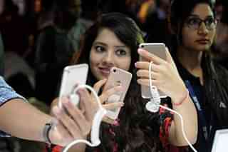A woman takes a selfie on a smartphone. (Burhaan Kinu/Hindustan Times via Getty Images)