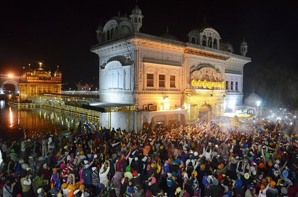 Sikh devotees spray perfume on the Palki Sahib, which carries the Sikh holy books, to mark Hola Mohalla at the Golden Temple in Amritsar. (Sameer Sehgal/Hindustan Times via Getty Images)