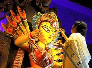 New-found love for Hindu festivals: West Bengal Chief Minister Mamata Banerjee sketches the eyes of goddess Durga on the auspicious day of Mahayala at Chetla Agrani Club in Kolkata. (Subhendu Ghosh/Hindustan Times via GettyImages)