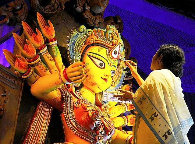 New-found love for Hindu festivals: West Bengal Chief Minister Mamata Banerjee sketches the eyes of goddess Durga on the auspicious day of Mahayala at Chetla Agrani Club in Kolkata. (Subhendu Ghosh/Hindustan Times via GettyImages)