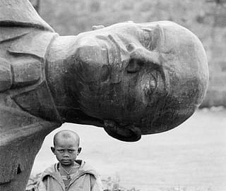 A boy stands beside a toppled Lenin statue in Ethiopia in 1991. (image via Reddit)&nbsp;