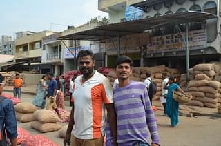 Daily worker Yogesh Kumar with his colleague Venkatesh at the onion auction platform of the Yeshwanthpur APMC yard.&nbsp;