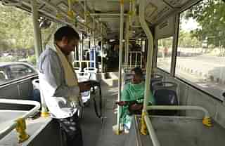 A woman buys a ticket in a DTC bus (Vipin Kumar/Hindustan Times via Getty Images)