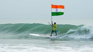 Murthy Megavan surfs holding the national flag