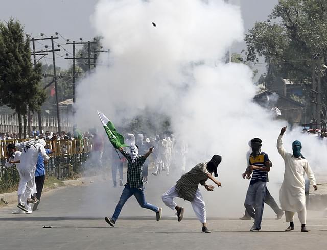 Kashmiri protesters pelting stones at the police and paramilitary soldiers. (Waseem Andrabi/Hindustan Times via Getty Images)