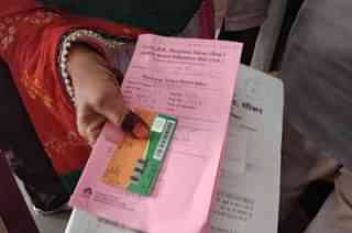 Jaitun Bano holding Pappi Bano’s Bhamashah Card and discharge and prescription papers.