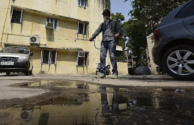 South Delhi Municipal Corporation worker sprays mosquito repellent at a house in Lajpat Nagar II during an anti-dengue drive in New Delhi. (Raj K Raj/Hindustan Times via Getty Images)
