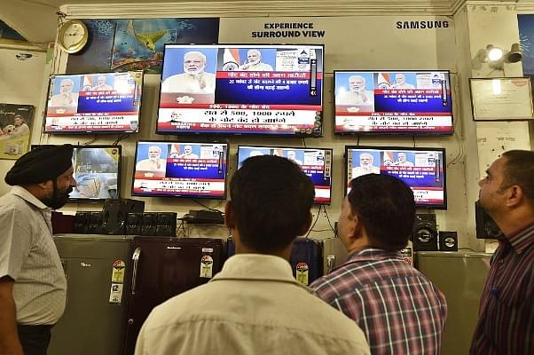  People watching TV during Prime Minister Narendra Modi’s address to the nation on 8 November 2016, when he announced the scrapping of Rs 500 and Rs 1,000 notes. (Sanjeev Verma/Hindustan Times via Getty Images)