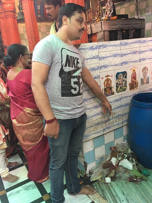 A volunteer at the Kal Bhairav temple points to an unused dustbin.