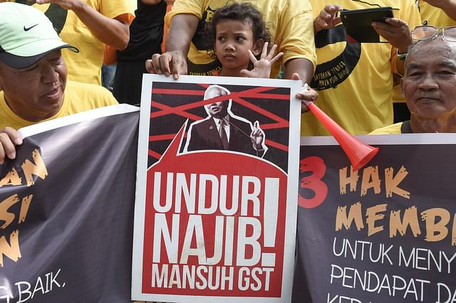 Protesters hold anti-GST placards in Kuala Lumpur (Mohd Rafsan/AFP via Getty Images)