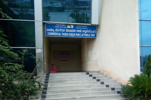 A forlorn Attibele checkpost on Tamil Nadu-Karnataka border with a flower vendor finding space to tie up flowers.