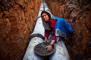 An Indian woman works at a construction project in front of the Jawaharlal Nehru Stadium in New Delhi. (Daniel Berehulak/Getty Images)