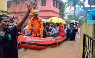 Rescuers shift people to a safer place from a flooded locality in Mangaluru.