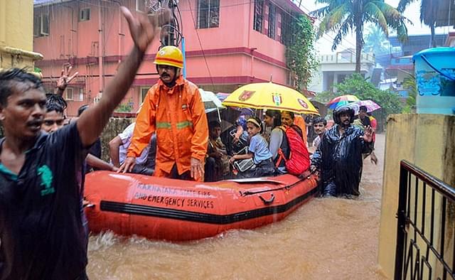Rescuers shift people to a safer place from a flooded locality in Mangaluru.