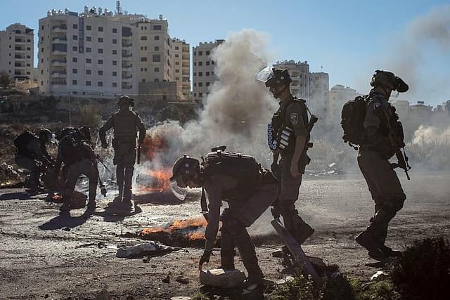Israeli forces clear a road block placed by Palestinian protestors. (Chris McGrath/Getty Images)