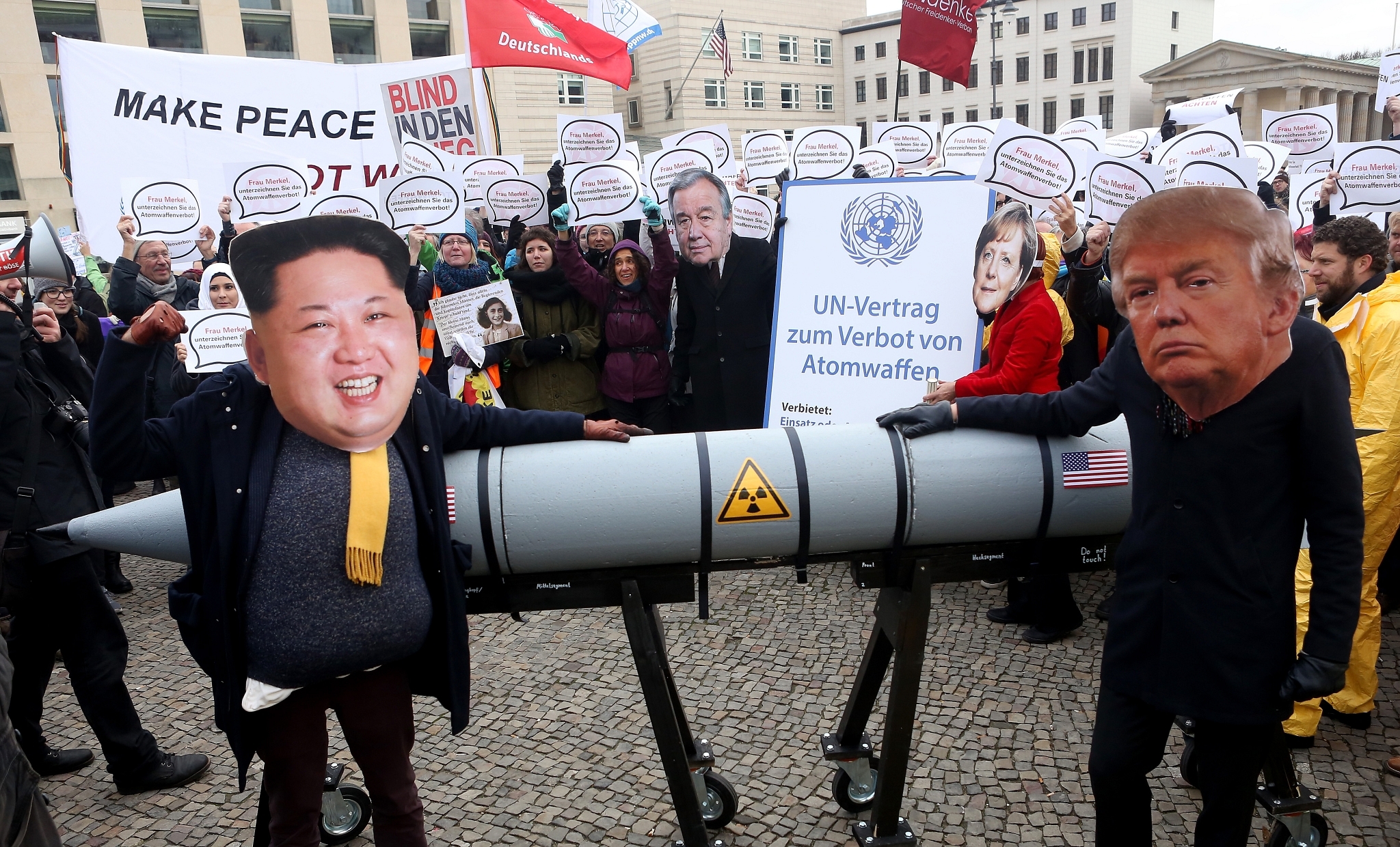 Activists in Berlin pose with masks of Donald Trump and Kim Jong-Un along with a model of a nuclear rocket in 2017 (Adam Berry/Getty Images)