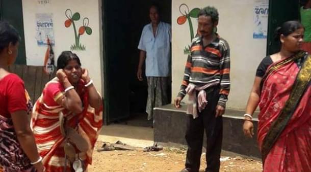 A woman with a garland of shoes around her neck and squatting holding her ears in front of TMC office (Twitter/@me_sourish).