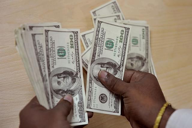 A customer counts dollars at a money exchange desk in India. (STRDEL/AFP/Getty Images)&nbsp;