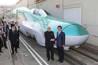 Prime Minister Narendra Modi  and his Japanese counterpart Shinzo Abe  shake hands in front of a shinkansen train during their inspection at a bullet train manufacturing plant in Kobe, Hyogo prefecture on 12 November 2016. (JIJI PRESS/AFP/Getty Images)