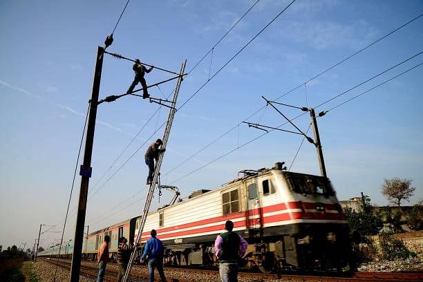 Indian Railways workers repair high voltage train power lines in Jalandhar. (Photo credit should read SHAMMI MEHRA/AFP/Getty Images)