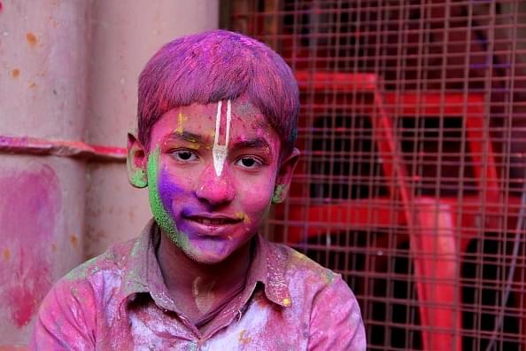 A boy poses for a picture during Holi celebrations in Vrindavan