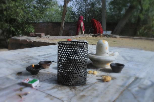 Women at a temple draw water from the well. They would have the first sip after offering it to the trees.