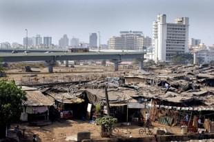 Slum dwellings surrounding a newly-built flyover in Mumbai. (SEBASTIAN D’SOUZA/AFP/GettyImages)