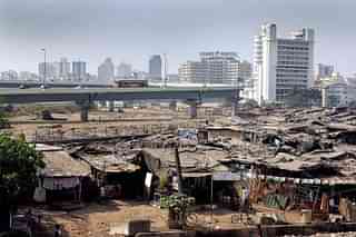 Slum dwellings surrounding a newly-built flyover in Mumbai. (SEBASTIAN D’SOUZA/AFP/GettyImages)