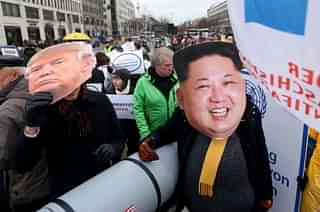 An activist with a mask of Kim Jong-un and another with a mask of Donald Trump march with a model of a nuclear rocket during a demonstration against nuclear weapons in Berlin, Germany.&nbsp; (Adam Berry/Getty Images)&nbsp;