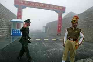 Indian and Chinese soldiers at a border crossing. (Diptendu Dutta/GettyImage)