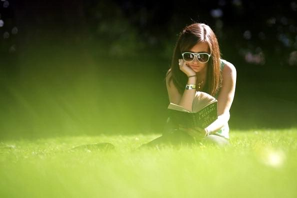 A woman reads a book in the sunshine in Victoria Tower Gardens in London. (Peter Macdiarmid/GettyImages)&nbsp;