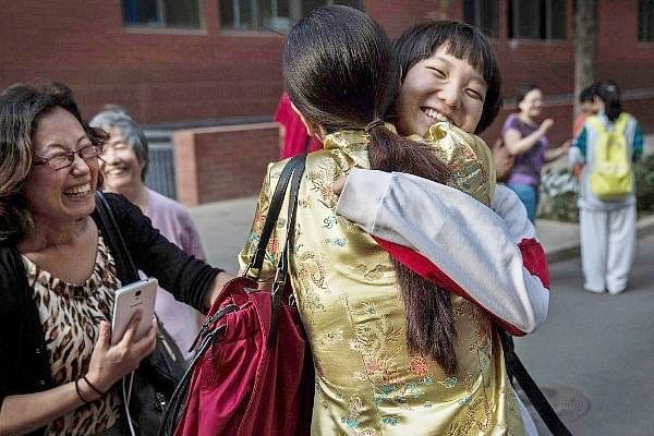 A Chinese student is hugged by relatives after completing the Gaokao at the Beijing Renmin University Affiliated High School, in Beijing, China. (Kevin Frayer/Getty Images)