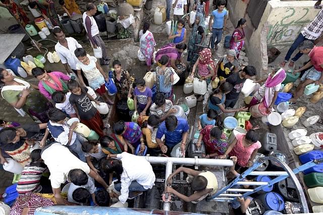 People queue up for water in Delhi as shortage plagues the country (Sonu Mehta/Hindustan Times via Getty Images)