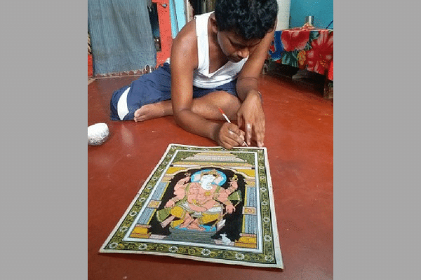 Artist Narayan Mahapatra paints a Ganesha on a canvas