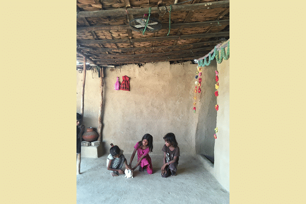 Children play with a rabbit even as the fan above them stopped working a month ago