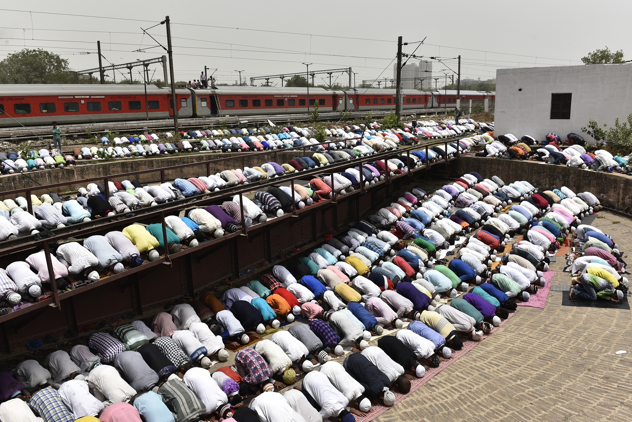 Devotees take part in the afternoon prayers  at the railway yard of the New Delhi Railway Station. (Sanchit Khanna/Hindustan Times via Getty Images)